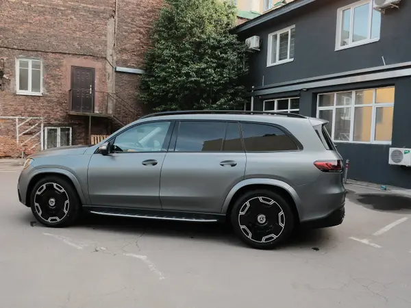 Mercedes-Benz GLS серый матовый после антихрома, вид сбоку на фоне здания