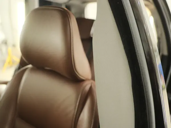 Подголовник и спинка кожаного сиденья коричневого цвета после профессиональной химчистки