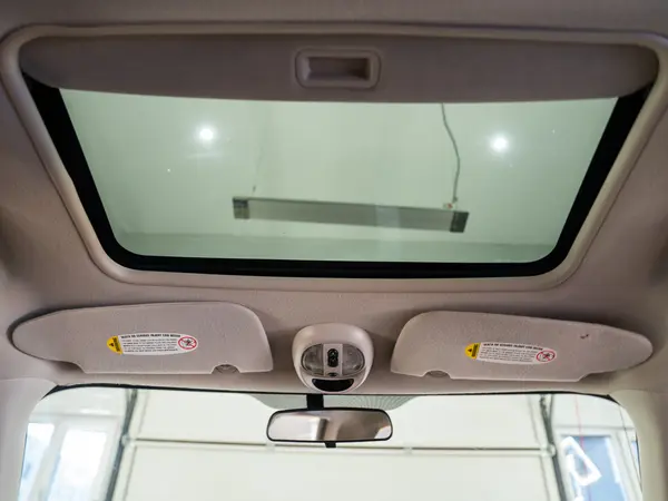 Потолок салона автомобиля с люком после химчистки — чистая обивка, солнцезащитные козырьки и зеркало