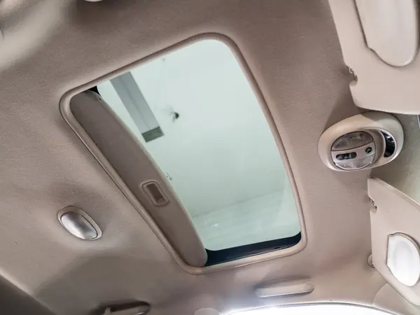 Потолок салона автомобиля с люком после химчистки — бежевая обивка без пятен и загрязнений