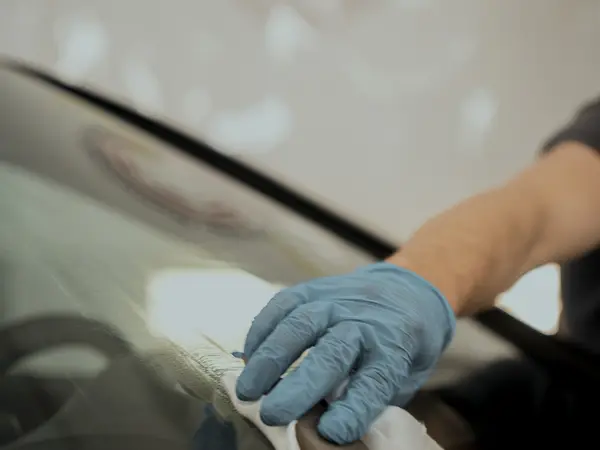 Мастер АЦ Полимер наносит керамическое покрытие на кузов автомобиля с помощью аппликатора и флакона