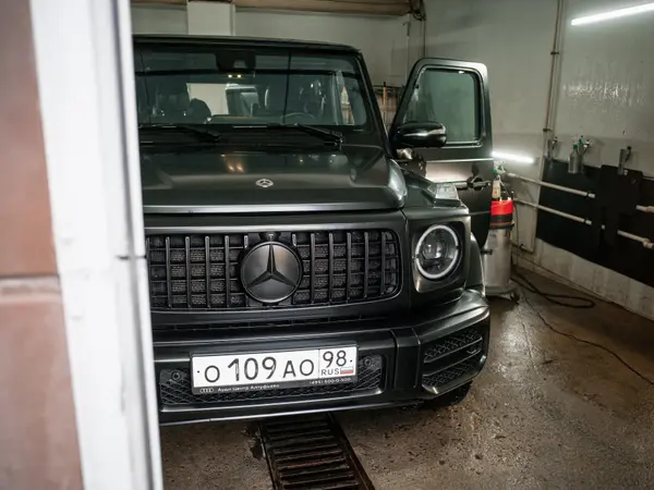 Чёрный Mercedes-Benz G-Class в боксе детейлинг-мойки, вид спереди