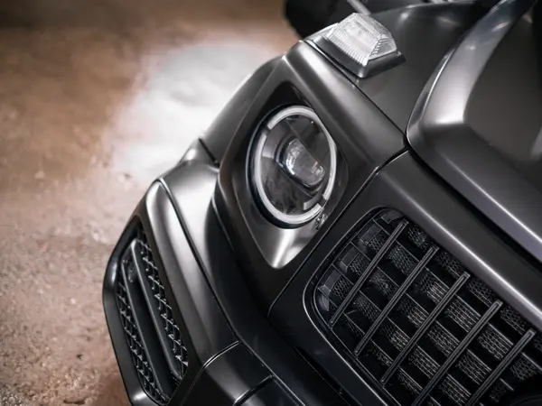 Передняя фара и решётка Mercedes-Benz G-Class крупным планом после мойки, матовый кузов