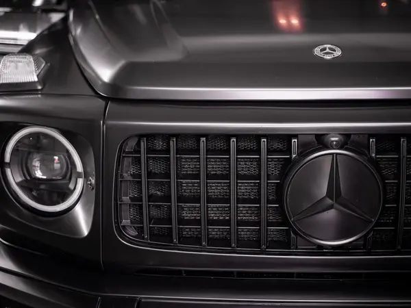 Решётка радиатора и фара чёрного Mercedes-Benz G-Class крупным планом после детейлинг-мойки