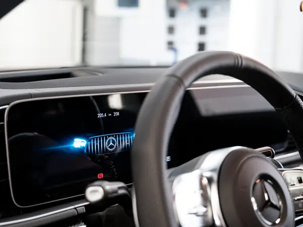Руль и цифровая приборная панель Mercedes-Benz с логотипом на экране после оклейки интерьера