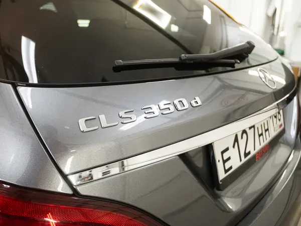 Задняя часть Mercedes-Benz CLS 350d крупным планом — шильдик и крышка багажника после полировки