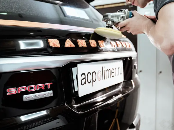 Задний бампер Range Rover Sport до полировки — мастер обрабатывает поверхность машинкой