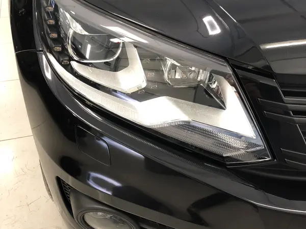 Передняя фара тёмного Volkswagen после полировки — прозрачная линза без помутнений