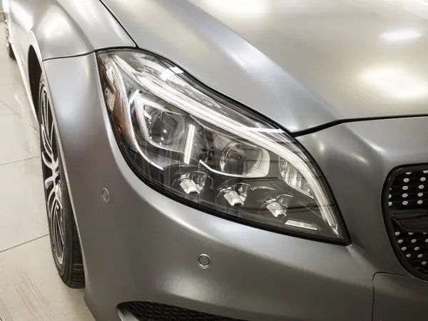 Передняя фара серебристого Mercedes-Benz CLS после полировки — кристально чистая оптика