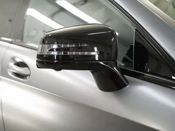 Отполированное боковое зеркало Mercedes-Benz в чёрном глянце крупным планом