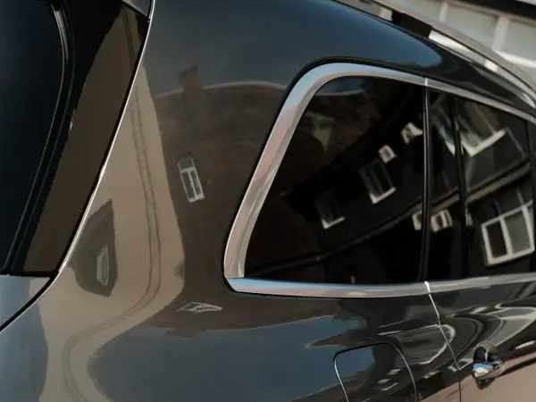 Крупный план задней стойки чёрного автомобиля — отражения в отполированном стекле