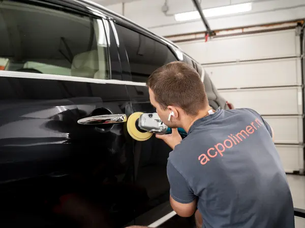 Мастер АЦ Полимер полирует дверь чёрного автомобиля — процесс восстановительной полировки