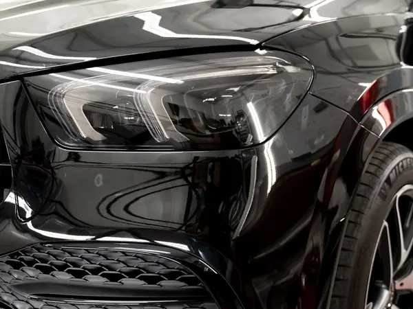 Передняя LED-фара чёрного Mercedes-Benz крупным планом после тонировки