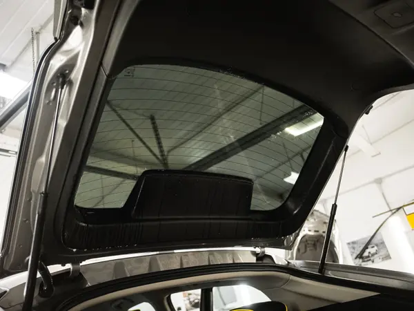 Тонировочная плёнка на заднем стекле автомобиля, вид изнутри через открытый багажник